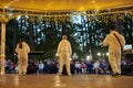 Local pop rock music band performs in gazebo of city public park, energetic outdoor performance