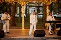 Local pop rock music band performs in gazebo of city public park, energetic outdoor performance