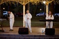 Local pop rock music band performs in gazebo of city public park, energetic outdoor performance