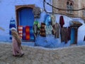 Local products hanging on blue wall in Morocco. for sale.