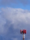 Red and white mobile phone tower against a later afternoon winter sky. Royalty Free Stock Photo