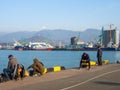 Local residents on amateur sea fishing. The backs of fishermen on the pier. Outdoor recreation Royalty Free Stock Photo