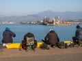Local residents on amateur sea fishing. The backs of fishermen on the pier. Outdoor recreation Royalty Free Stock Photo