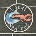 Local Seafood sign on old black and white wall with fish and lobster illustration