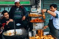 A local selling fried chicken at the street market in Delhi, India.