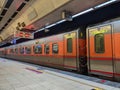 A local silver and orange train waiting for passengers with doors closed on the 4B platform in Taipei Train Station with