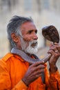 Local snake charmer holding Indian cobra in the street of Jaipur