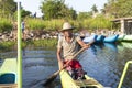 Habrana, Sri Lanka: 03/16/2019: Local Sri Lankan man paddling tourist boat on a lake. He is wearing traditional straw hat