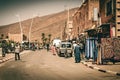 Local street in an old village in Morocco with people in traditional clothing and small roadside shops. Foum Zguid. Royalty Free Stock Photo