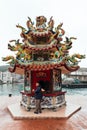 Local Taiwanese man looks at the camera while burning Joss Paper inside the Chinese Shrine in Yehliu fisherman village.