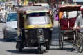 Local taxi and car move by the street in Jaipur, India.