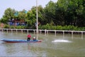 Local Thai fisherman driving traditional wooden thai longtailboat on river lake countryside Thailand