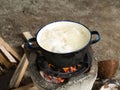 Local traditional Thai kitchen. Using stove for cooking by boil in pot on bonfire with orange flames and firewood Royalty Free Stock Photo