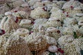 Local traditional Thai style flower offering on temple floor including pile of jasmine garlands made of white jasmine