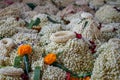 Local traditional Thai style flower offering on temple floor including pile of jasmine garlands made of white jasmine