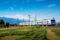 A local train of JR Izuhakone Tetsudo-Sunzu Line traveling through the countryside on a sunny spring day and Mt. Fuji in Mishima, Royalty Free Stock Photo