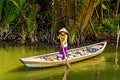Local Vietnamese woman in a canoe on a small river in the Mekong Delta. (Ho Chi Minh City, Vietnam - 2/01/2020