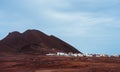 Local village Calhau at the foot of the volcanic crater. Single martian like dry red rock stand out from barren desert Royalty Free Stock Photo