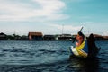 local woman crossing the lake on his canoe in front of the floating stilt house settlement