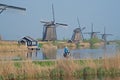 Local woman cycles along the famous windmills of Kinderdijk