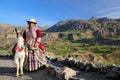 Local woman with llama standing at Colca Canyon in Peru