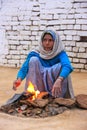 Local woman making fire using dry cow dung in Taj Ganj neighborhood of Agra, Uttar Pradesh, India