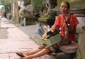 Local woman selling knives and other objects in the street of Denpasar, Bali