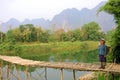 Local woman with traditional clothes at wooden bridge in Vang Vieng, Laos Royalty Free Stock Photo