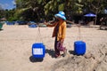 A local woman in Vietnam is taking fresh water to her fishing boat for a long day fishing in among the sea Royalty Free Stock Photo