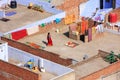 Local woman walking on a flat roof of the house in Jaipur