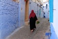 Local woman in black cloak in the city of Chefchaouen,Morocco