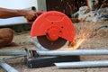 Local worker with electric circular steel cutting machine and sparkle