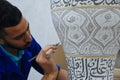 A local worker paints a large pot in Fez, Morocco.