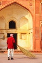 Local worker sweeping courtyard of Jahangiri Mahal in Agra Fort, Uttar Pradesh, India