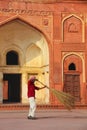 Local worker sweeping courtyard of Jahangiri Mahal in Agra Fort, Uttar Pradesh, India