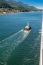 Tugboat guiding cruise ship in to port, Gastineau Channel, Juneau, Alaska, USA.