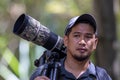 Local Young man traveler with carrying photography gear to taking photo of wildlife on Rainforest jungle