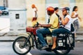 Locals riding a classic motorbike in Cuba.