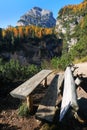 Wooden bench near Fanes Waterfall in the Dolomites, in a sunny autumn day.