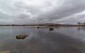 Loch Ba on Rannoch Moor in the Highlands of Scotland on a wet overcast day in April, with boulders on the surface of the water. Royalty Free Stock Photo