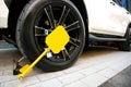 Lock the car with a special yellow shoe on the lock. Locked wheel car in a prohibited parking.