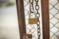 Lock on a chain link security fence. Chicken wire fence gate is locked with a chain and a padlock Royalty Free Stock Photo