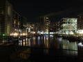 the lock entrance and moorings at clarence dock in leeds at night with buildings of the development reflected in the water and Royalty Free Stock Photo