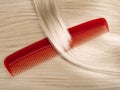 Lock of hair with red comb. Royalty Free Stock Photo