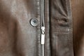 The lock on a lightning fastener and a button which is sewn in a leather jacket. Royalty Free Stock Photo
