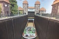 lock with long ship and two towers in the bakground . Cargo Boat is at the bottom of the lock ready to float upstairs . Bratislava