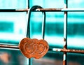 Lock made of rusty hearts fixed on a grid. Teal and orange filter Royalty Free Stock Photo