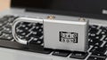 Lock sits on laptop keyboard displaying combination, showing security and technology at play in a workspace setting Royalty Free Stock Photo
