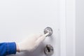 Lock repairman in protective gloves, installed a door handle Royalty Free Stock Photo