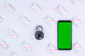 Lock, smartphone with green screen on a white background. Protection against hacking. White background with twisted marshmallow Royalty Free Stock Photo